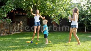 两个姐姐在后院的草地上向他们的小弟弟扔玩具飞机的4k镜头